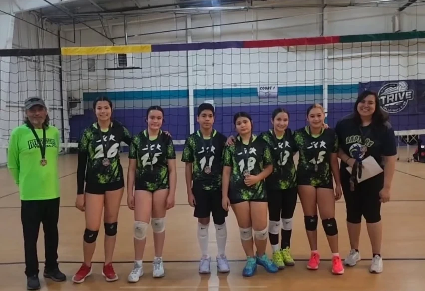 Raptors Flight 15U players and coaches at an indoor volleyball court